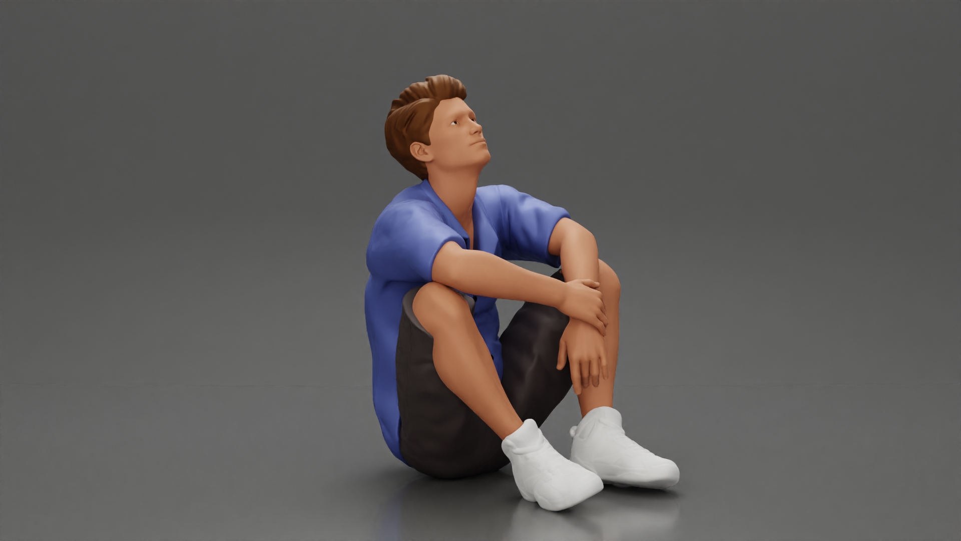 man sitting in shorts on the floor with hands on his knees